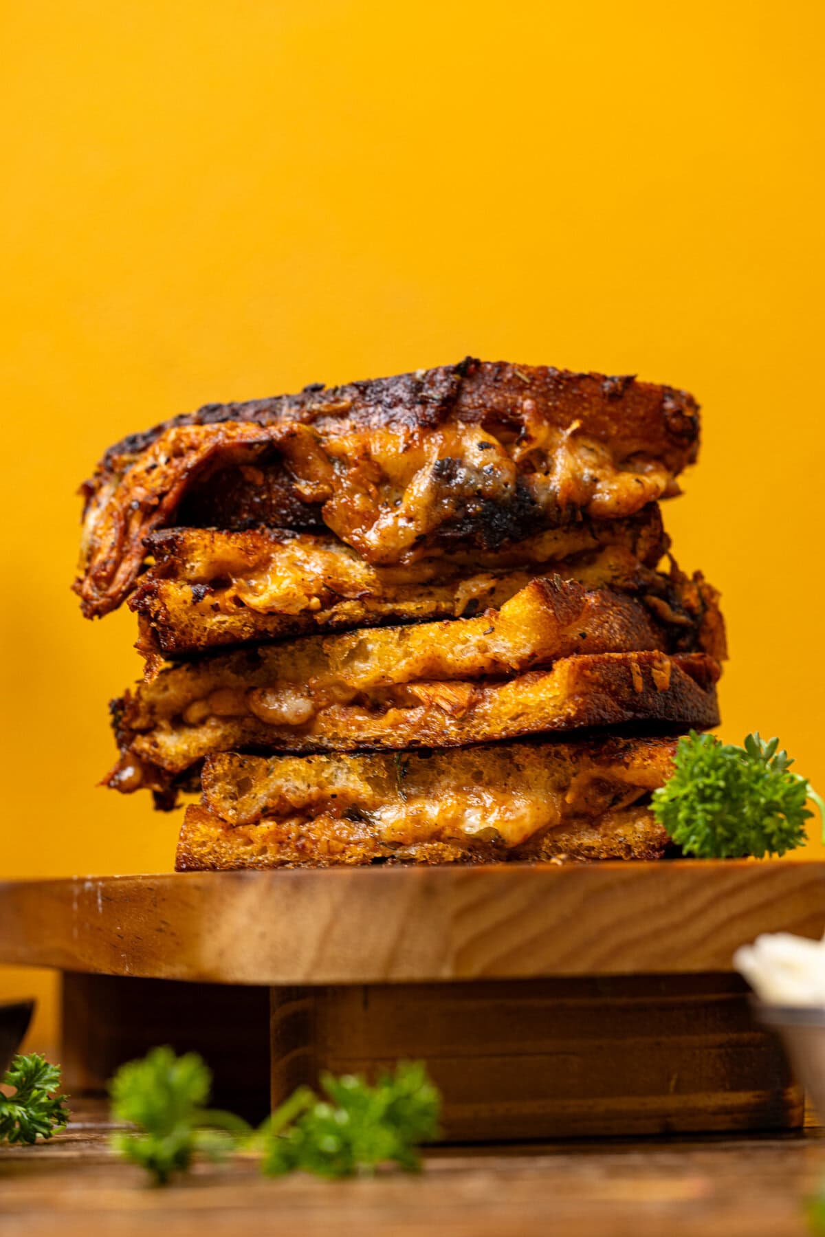 Photo of stacked grilled cheese on a wooden stand.