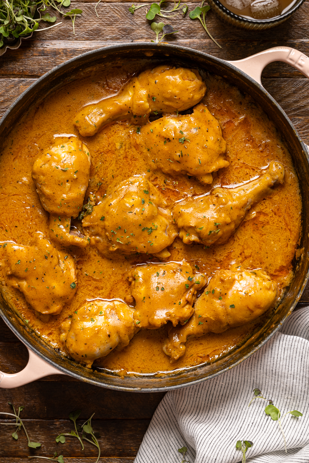 Image of chicken in a pot on a brown wood table.