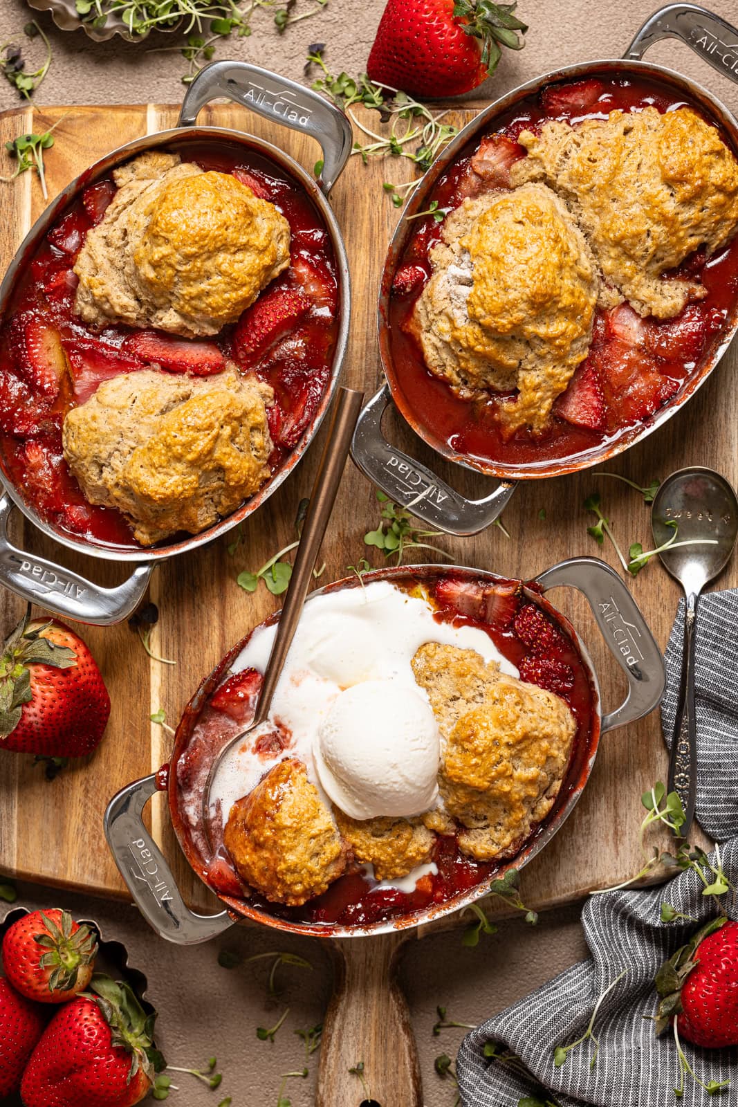 Photo of strawberry cobblers in mini baking dishes with strawberries.